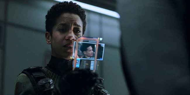 Naomi looks at a picture of her long lost son Filip, in The Expanse.  Her face is pained and she is scared for his future, prompting her to follow the others in the mass Exodus of Tycho.